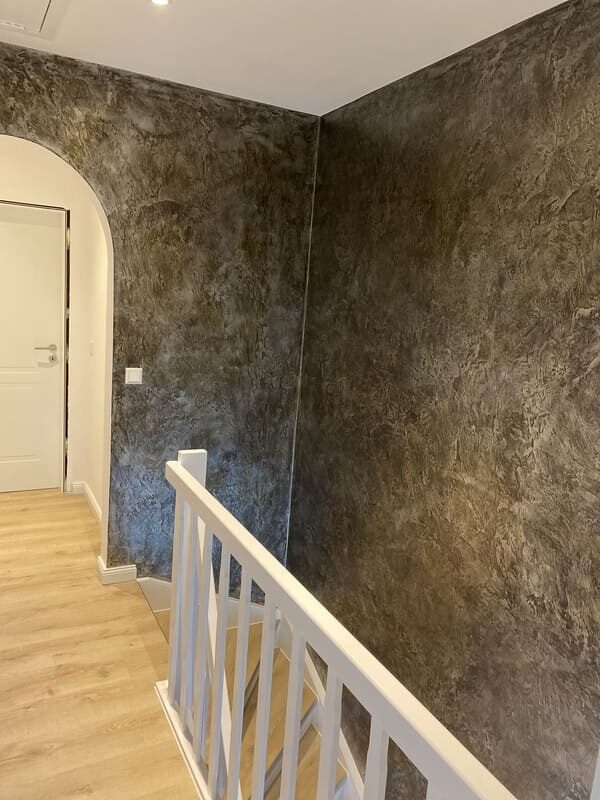 Treppenabsatz mit einer grau marmorierten Wand durch Spachteltechniken