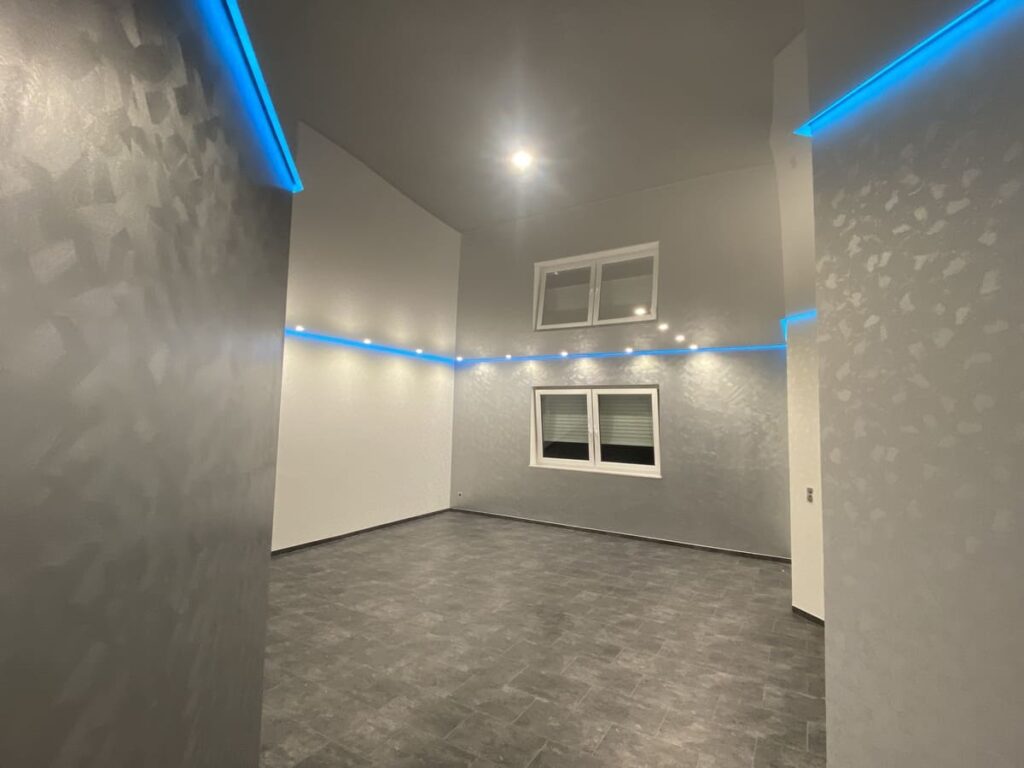 Graue Spanndecke mit indirekter blauer Beleuchtung